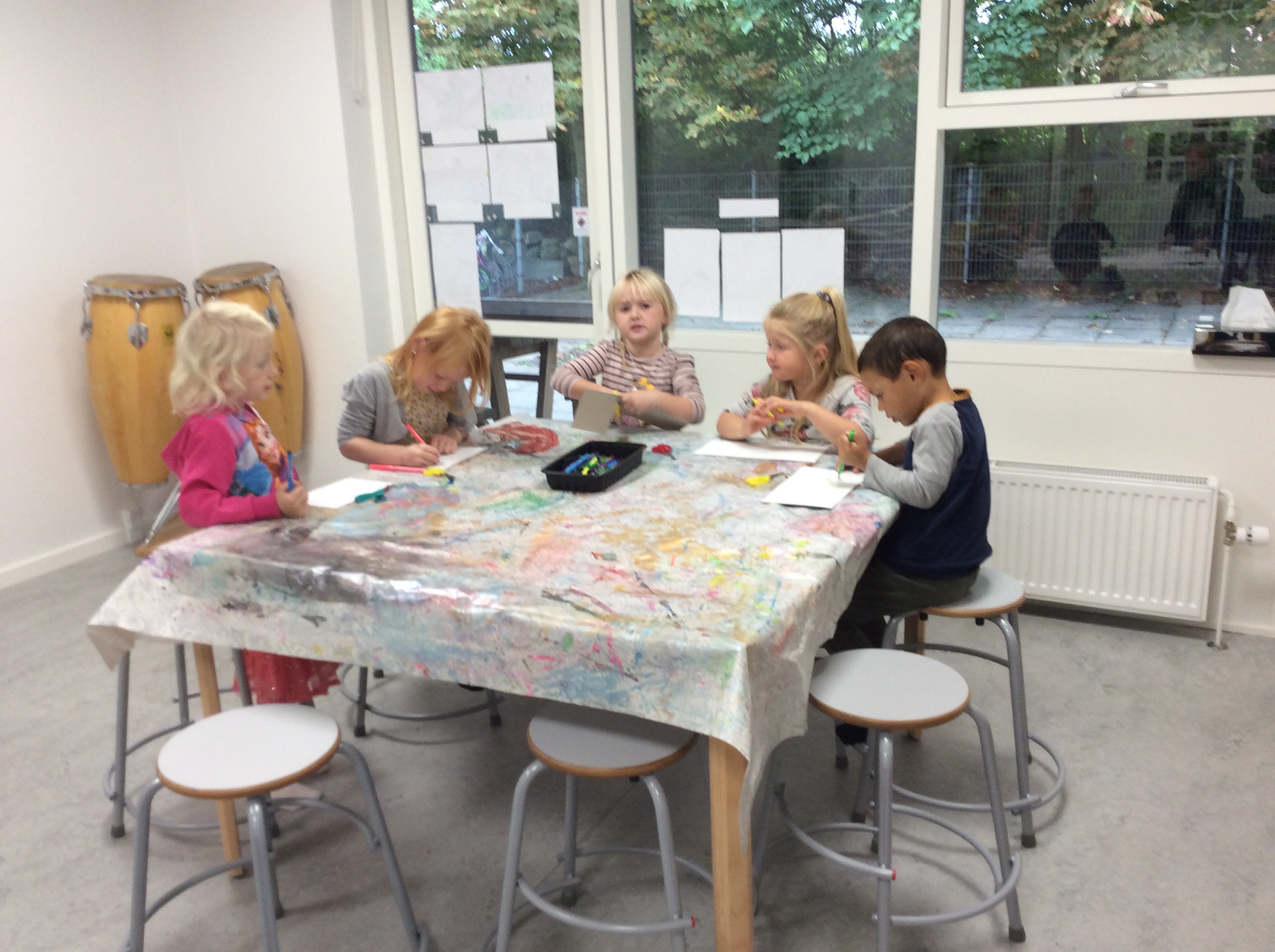 Flere børn tegner ved et bord