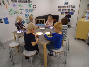 Flere børn klipper ved et bord